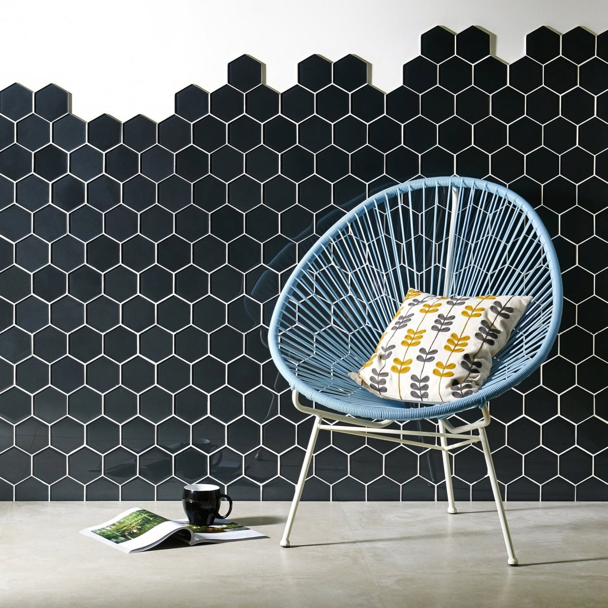 Hera Metallic Hexagon Mosaics black hexagon glass mosaic with a light blue woven chair