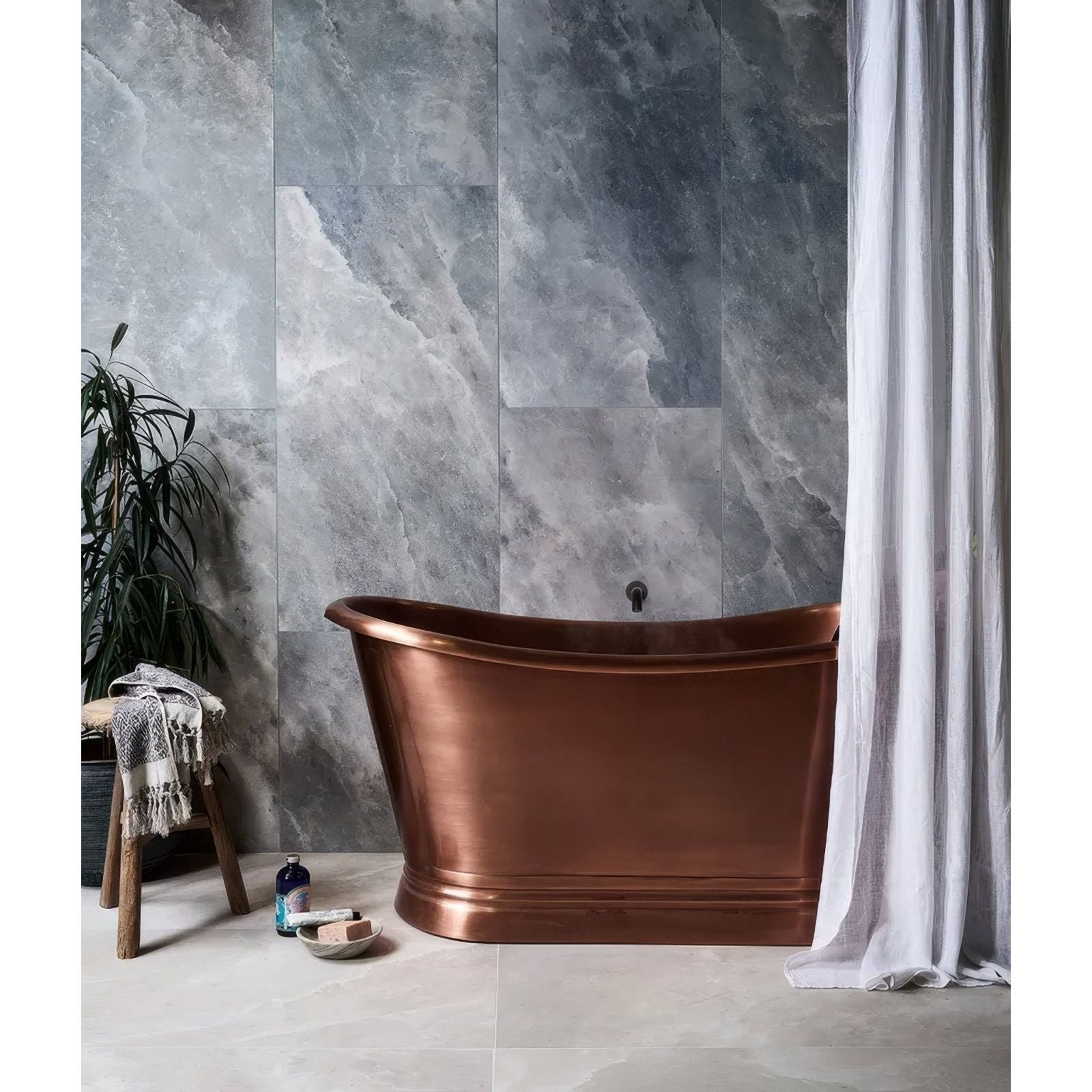 A sleek freestanding copper bathtub with polished finish and curved edges in Himalaya Porcelain Matt Ice style