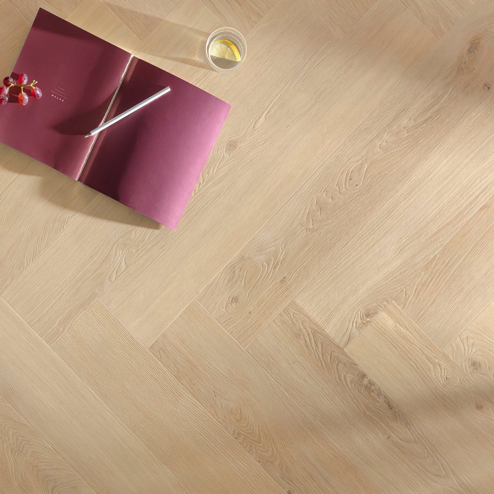 Light-colored wood plank flooring with a herringbone pattern from the hirame f300 herringbone collection