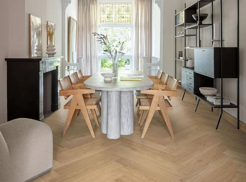 Light oak herringbone flooring in a dining room with a stone table