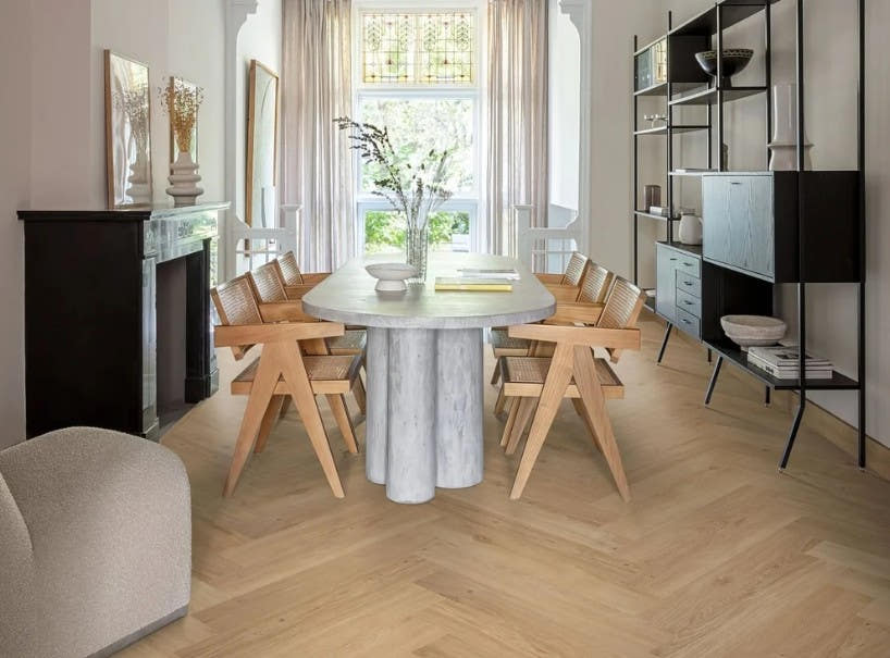 Light oak herringbone flooring in a dining room with a stone table