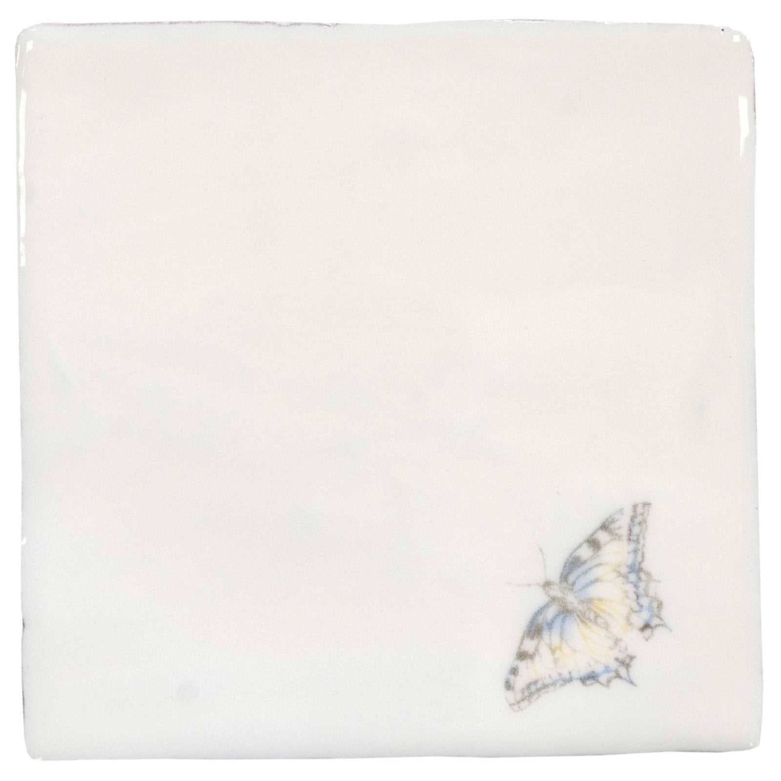 A delicate hand-painted butterfly in soft blue and yellow hues on an off-white ceramic tile indigo swallowtail pastel on cotton