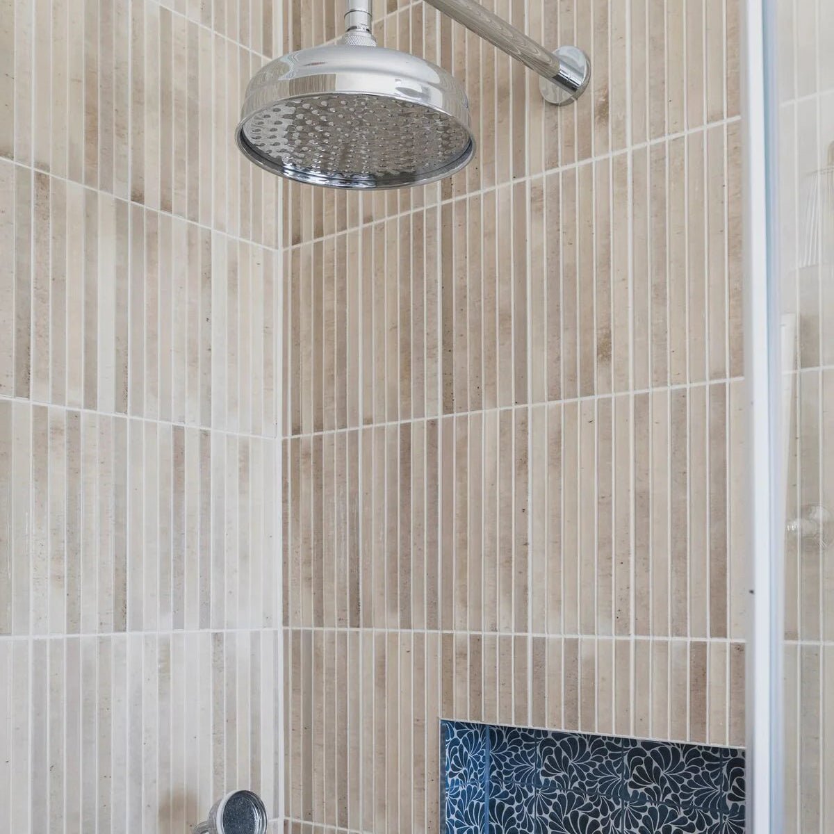 Chrome finished round showerhead with perforated face mounted on adjustable arm for ixworth ivory bar tile bathroom