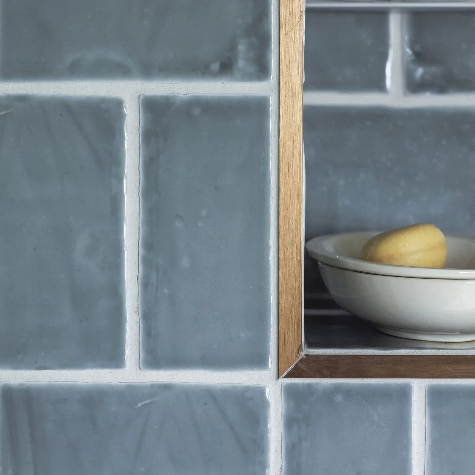 Jaipur dartmouth green rectangle glazed tile wall with a white ceramic bowl holding yellow soap on a wooden shelf