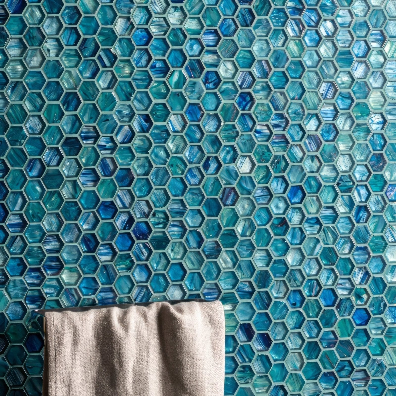 Blue hexagonal glass mosaic tile wall from Jaipur Glass Mosaic with a beige towel hanging below