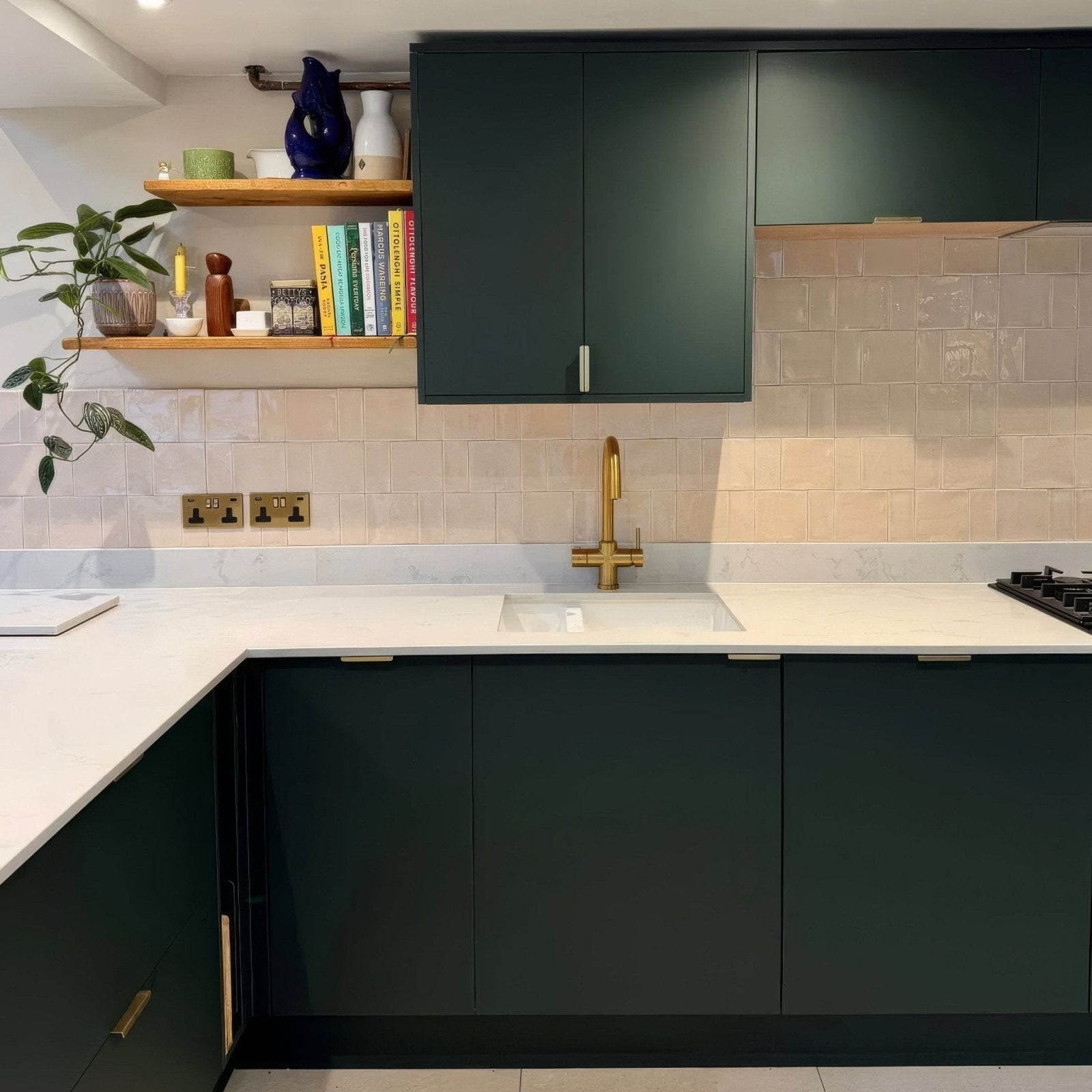 Jaipur old ochre square glazed tile in a kitchen with dark green matte cabinets and gold-toned handles and faucet