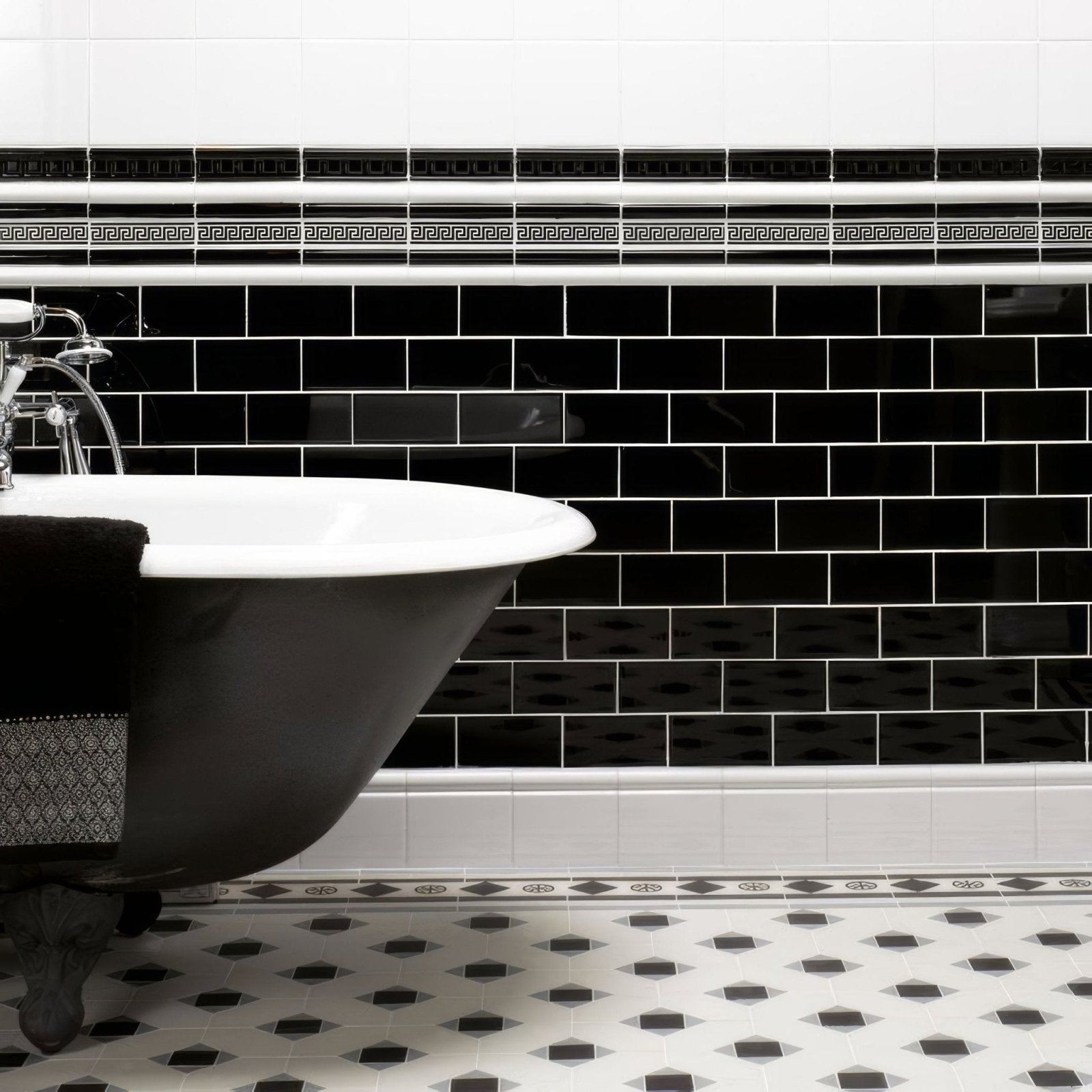 Jet black half tile glossy black subway tile wall with white grout and decorative border accents
