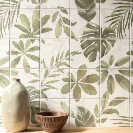A matte off-white ceramic vase with a slender neck and rounded body beside a textured brown bowl on jungle grove 16 tile panel