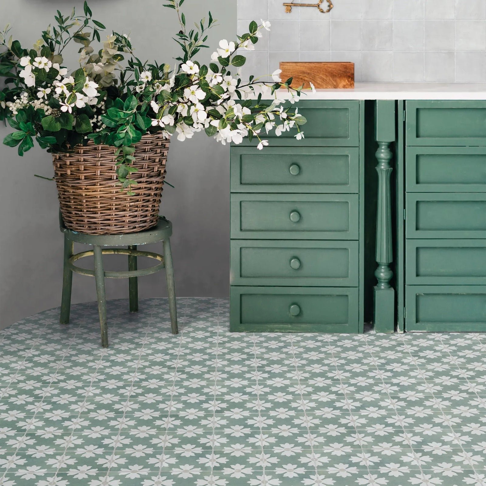 Green painted wooden dresser with four drawers and round knobs featuring kelmscott coleton blue patterned tile accents