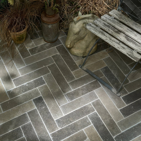 Dark gray herringbone patterned kimmeridge limestone tumbled and etched parquet stone tiles with textured finish