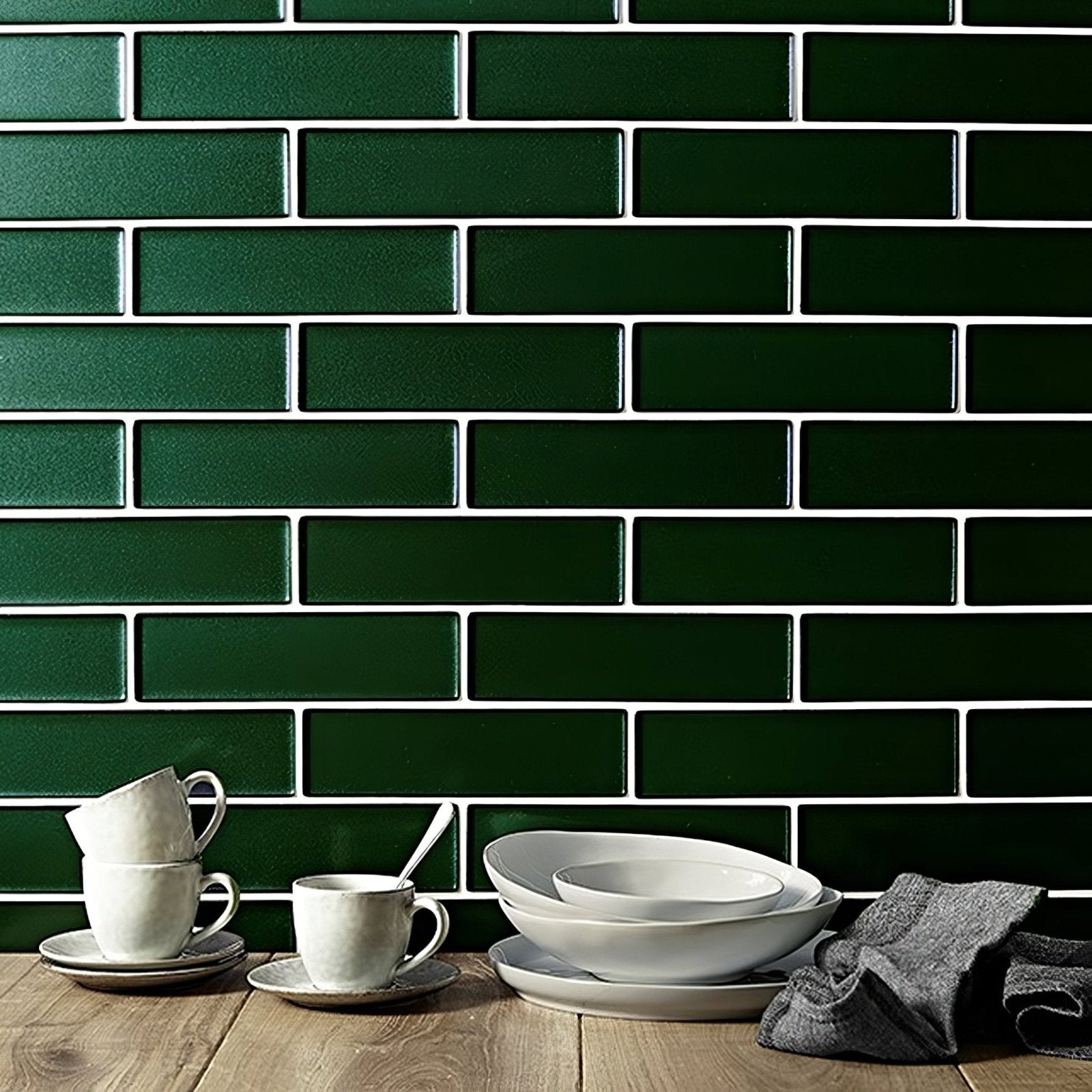 White ceramic coffee mugs and bowls on wooden surface against kingfisher green glass subway tile backsplash