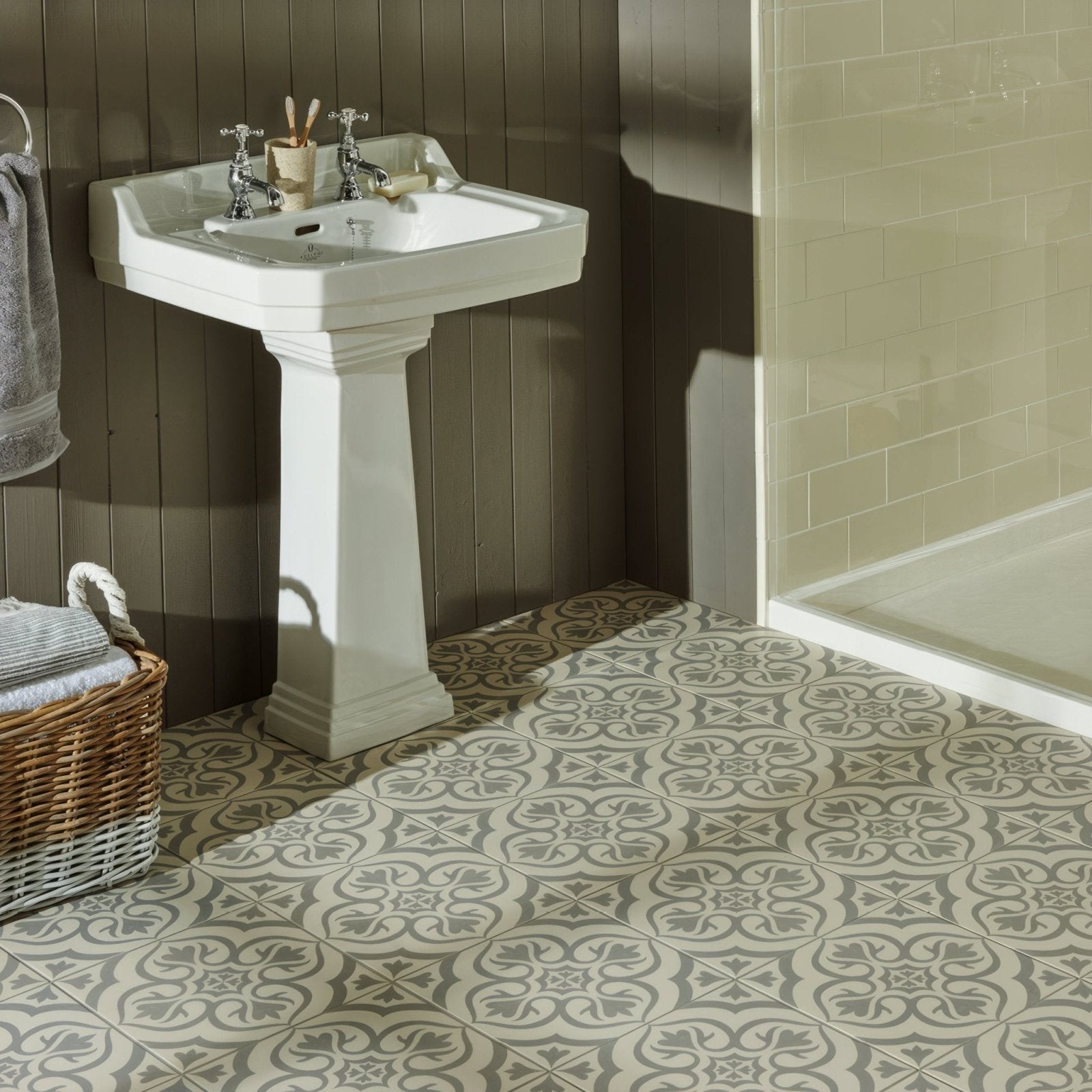 White ceramic pedestal sink with ornate detailing and chrome faucets in knightshayes light grey on chalk background
