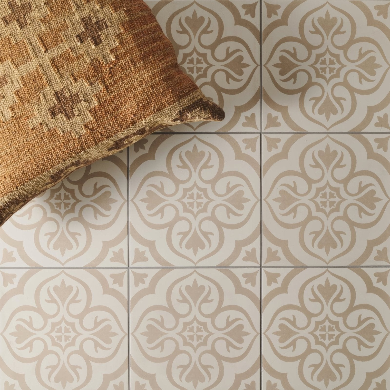 Beige and cream ornate patterned ceramic floor tiles knightshayes taupe on chalk with a woven brown pillow