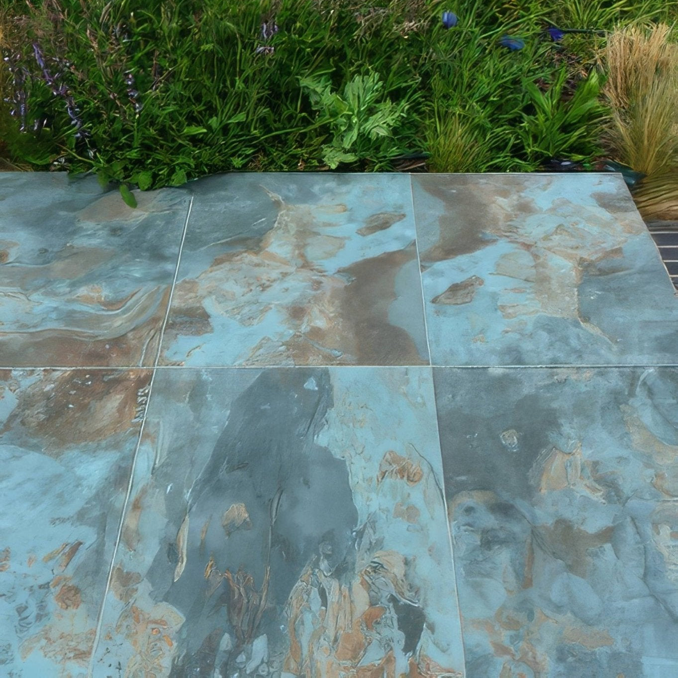 Komodo porcelain paving textured green blue and brown marble-effect patio tiles with natural veined pattern