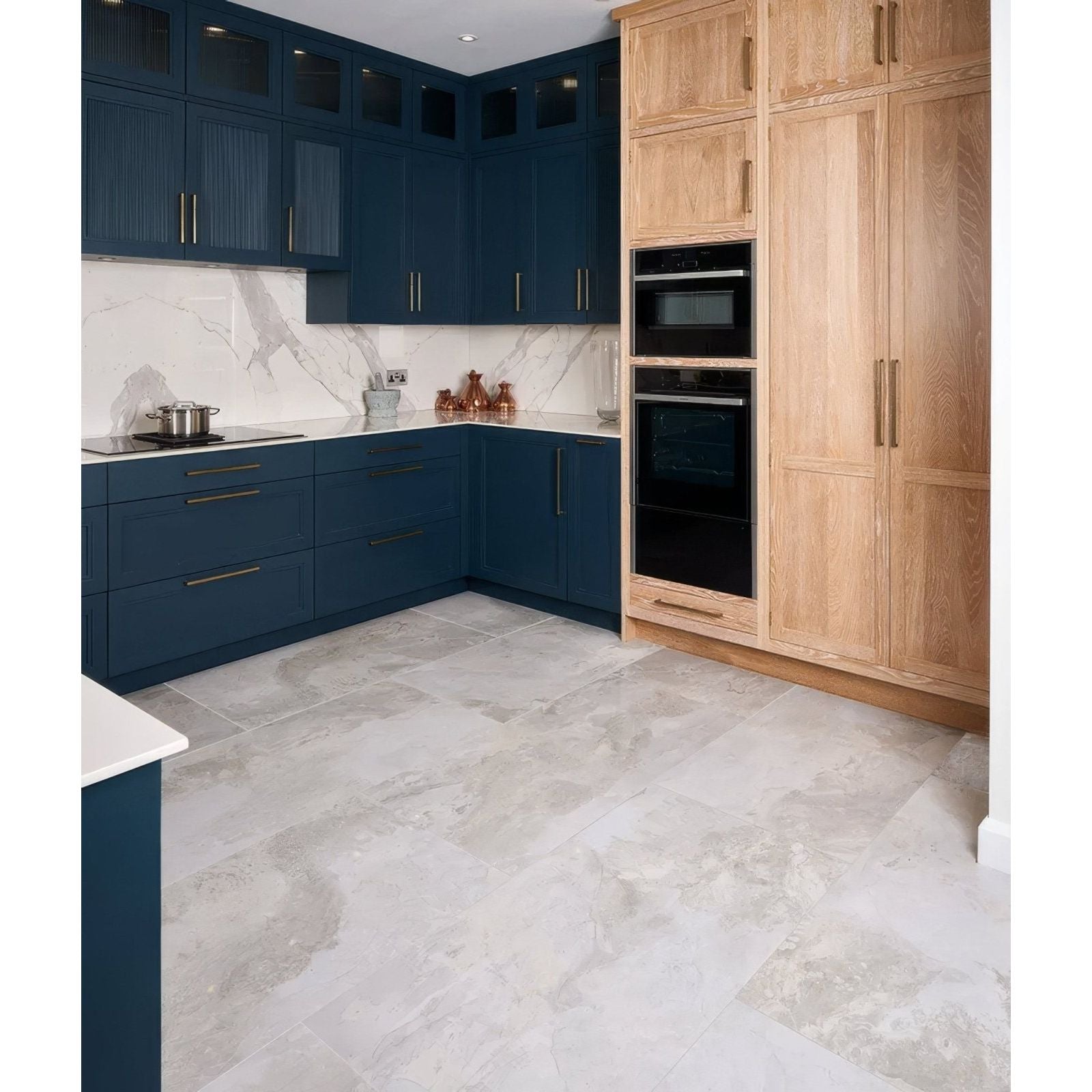 Deep blue komodo porcelain cabinetry with sleek gold handles and a white marble backsplash for modern kitchens