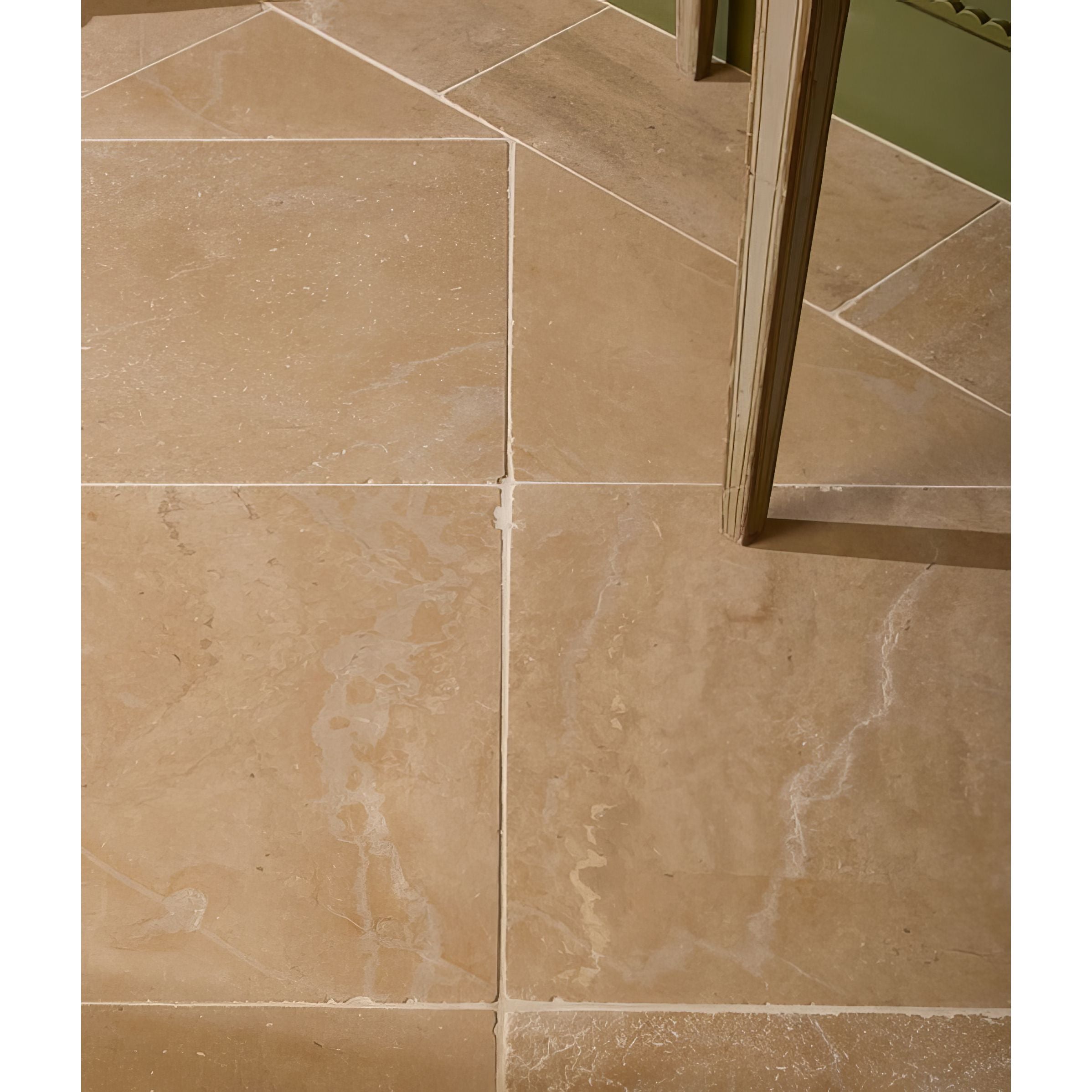 Close-up of beige tiles in Lacock Tumbled Limestone Flooring with a corner reflection