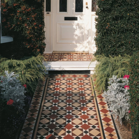 A classic lambeth front door in white with black glass panels and a brass letterbox framed by green hedges