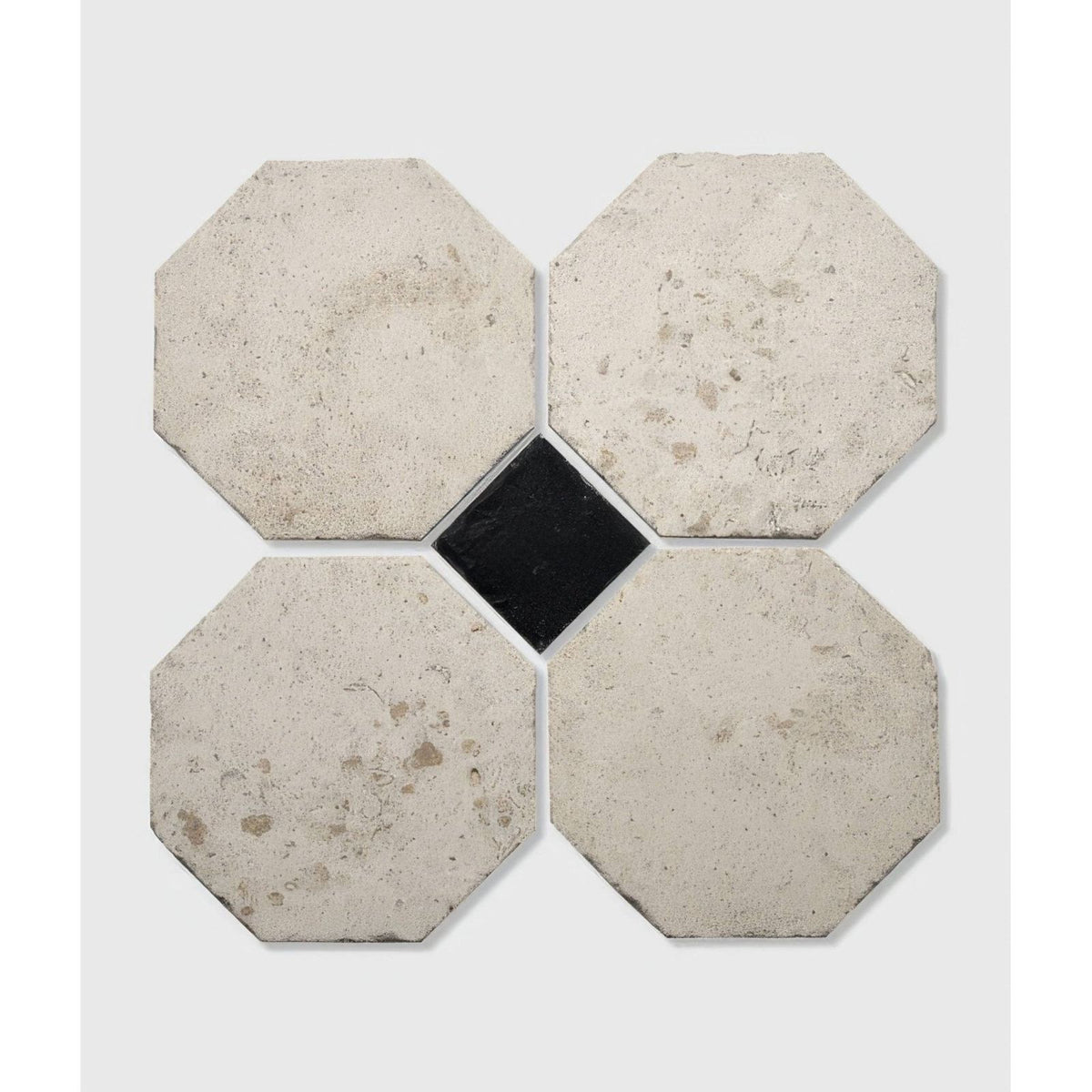 Four light gray textured limoges limestone octagonal tiles in a cross pattern with a black square tile center vintaged finish
