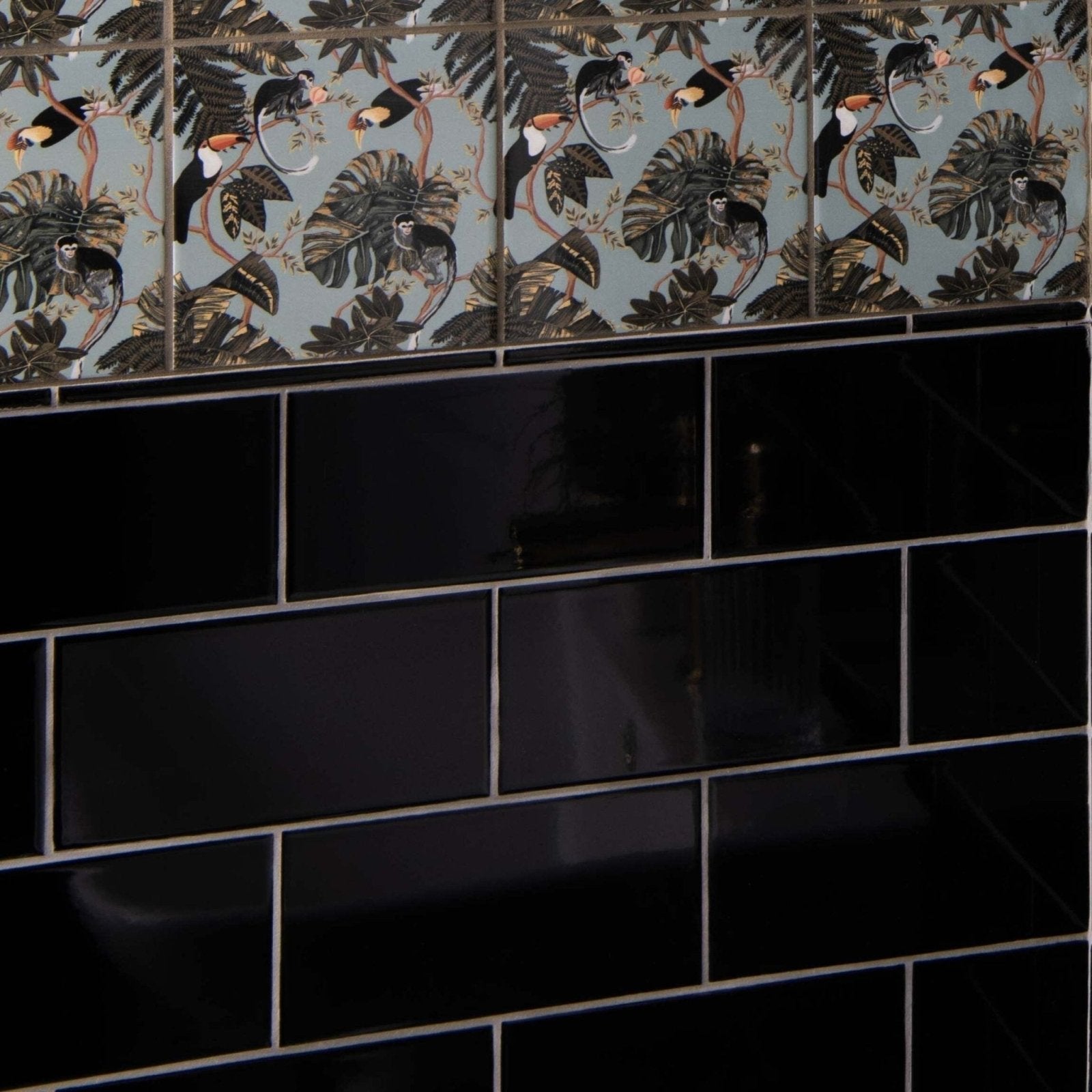 Liso Black Gloss 100x200 black glossy subway tiles with decorative tropical bird and foliage border on muted blue background
