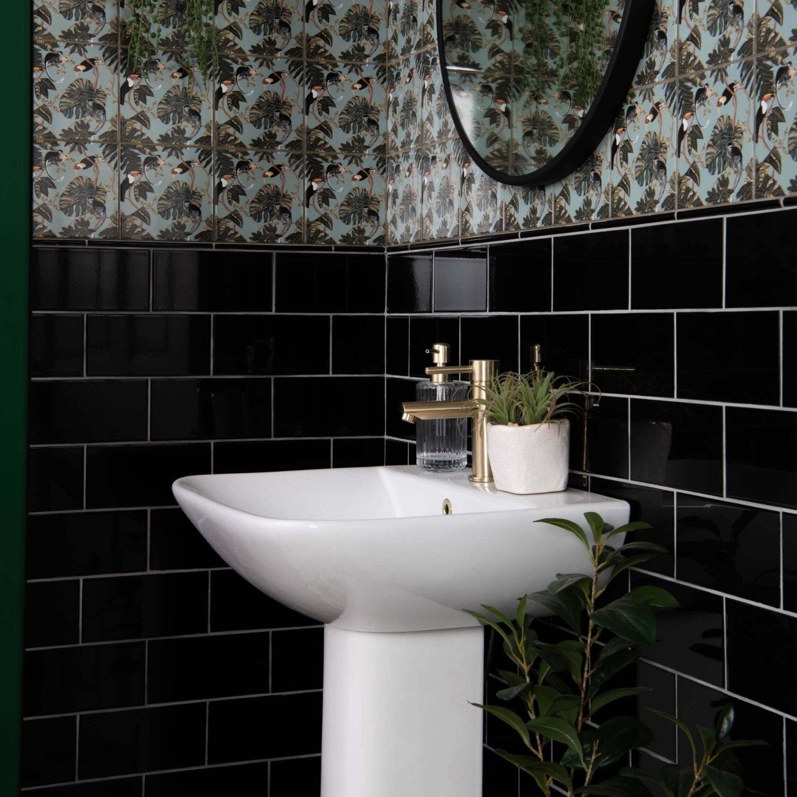 White ceramic pedestal sink with gold-toned faucet and soap dispenser in liso black gloss 100x200 bathroom setting