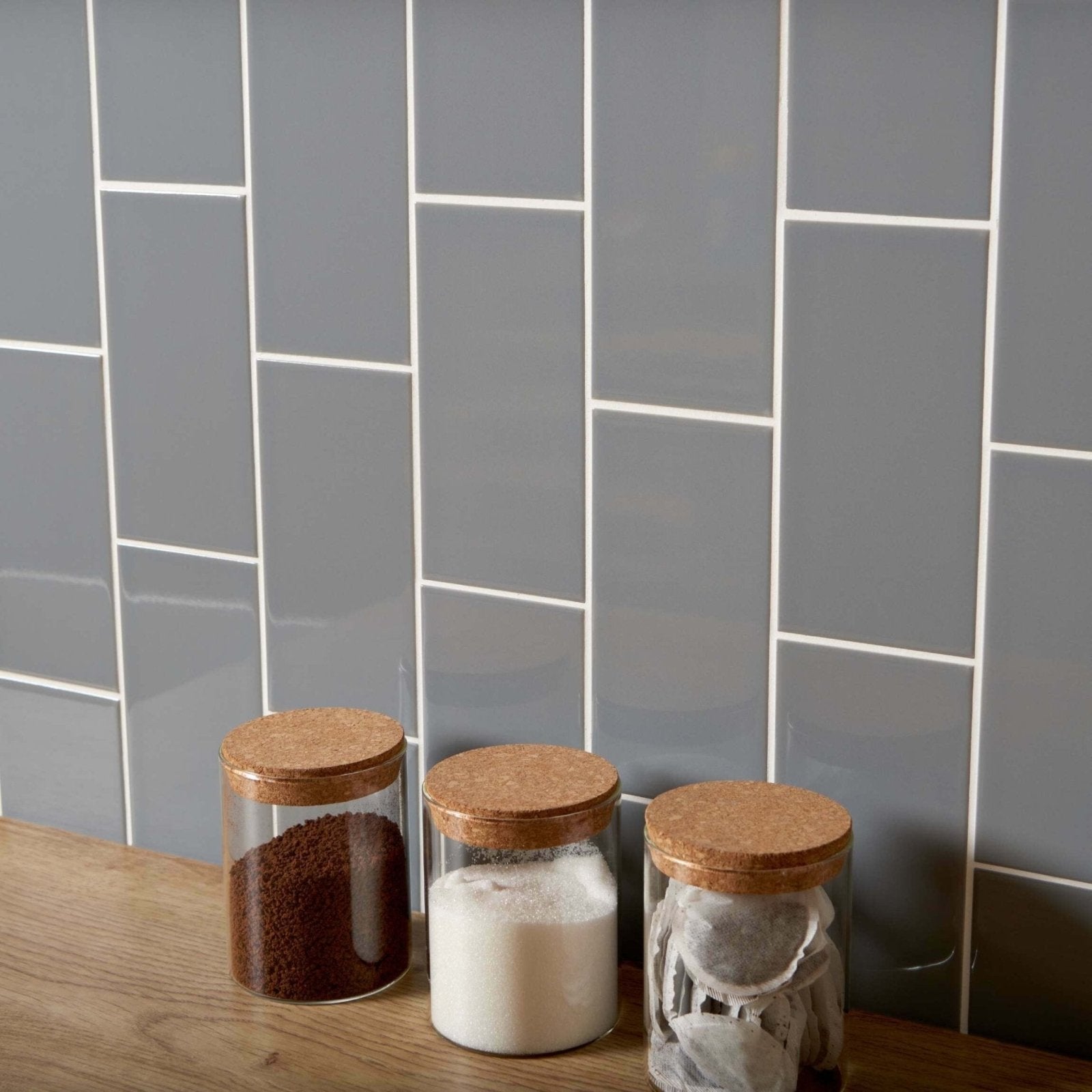 Three clear glass jars with natural cork lids containing kitchen staples in liso plata brillo 100x200 product