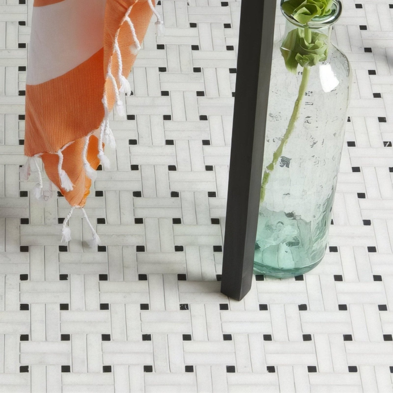 Long Island Marble Wicker Mosaic woven marble mosaic with a clear glass bottle holding a green rose