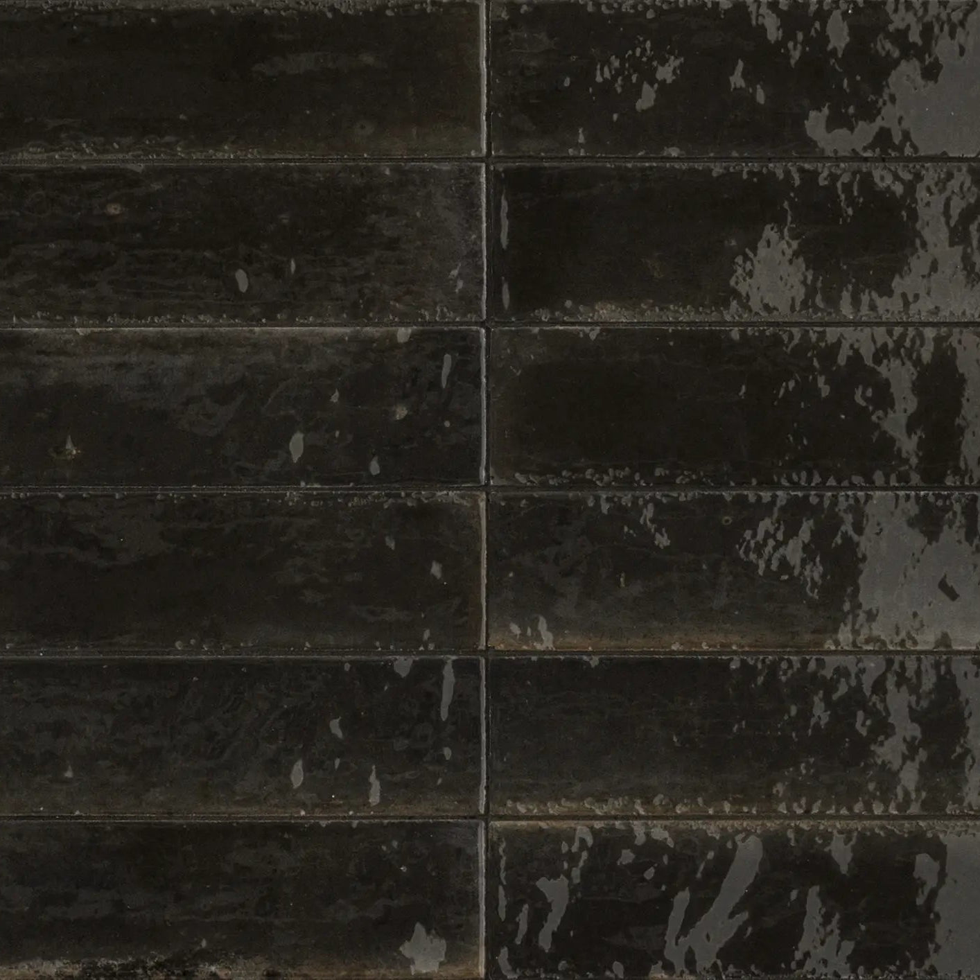 Dark gray rectangular luminous lume black tiles with distressed mottled finish arranged in a grid pattern