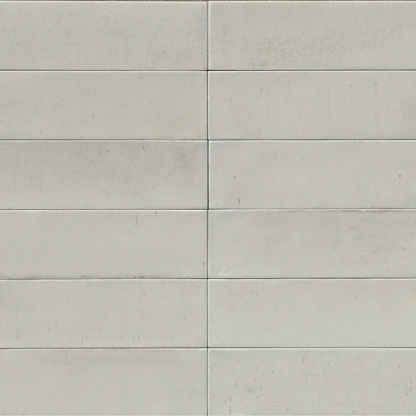 Light gray rectangular ceramic tiles arranged in a neat grid pattern from luminous lume classic white collection