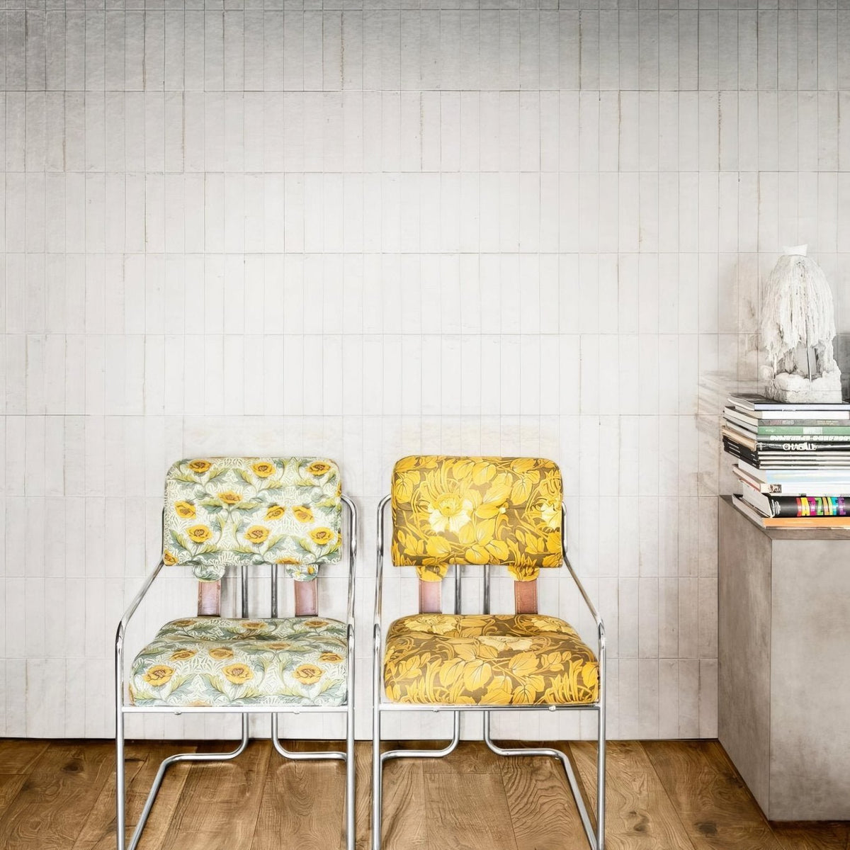 Two luminous lume white vintage-style chairs with chrome frames and bold yellow green cream floral upholstery