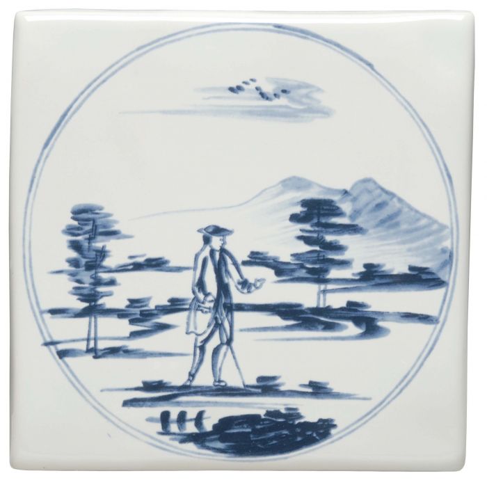 White ceramic tile with blue and white hand-painted man walking in a landscape scene titled man with stick in a landscape