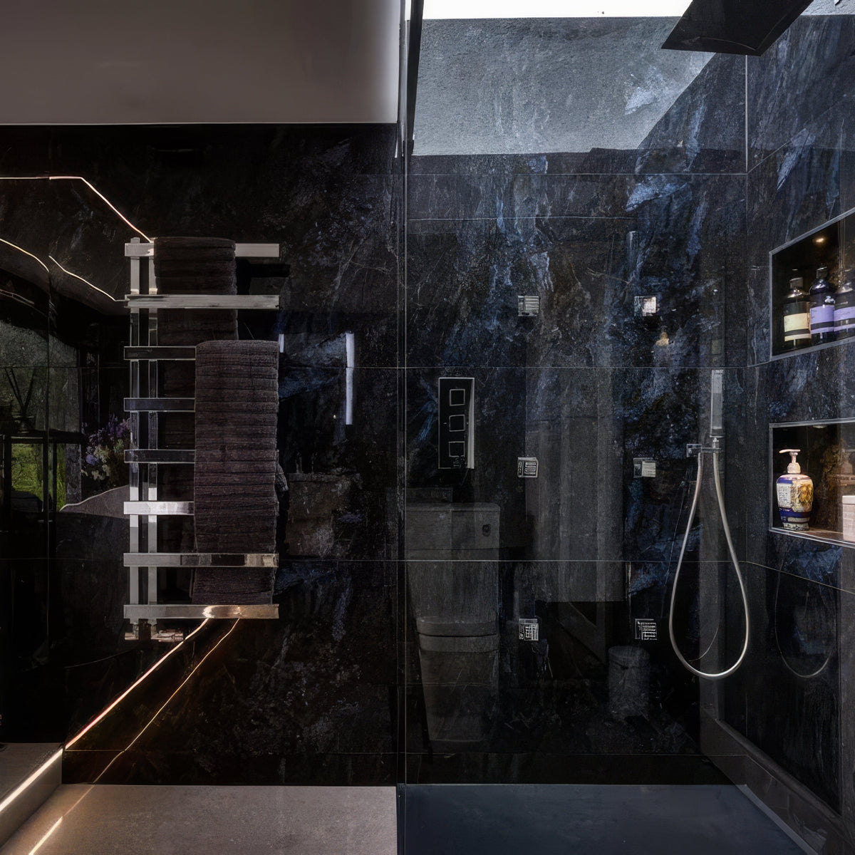 Marble Ocean Rock dark blue marble-effect shower walls with chrome fixtures and built-in shelves