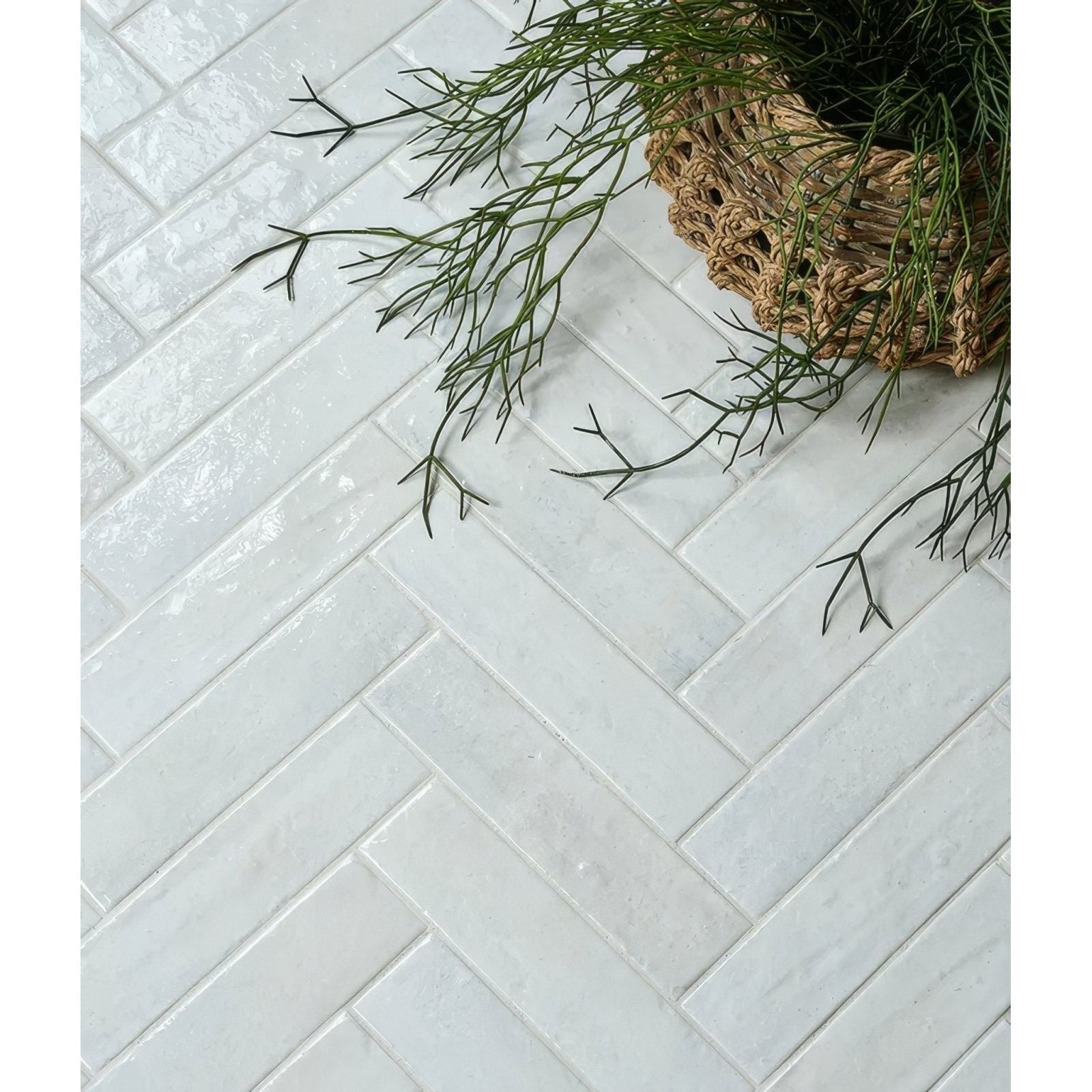 White rectangular ceramic tiles in a herringbone pattern from marlborough porcelain parquet cotton white gloss collection