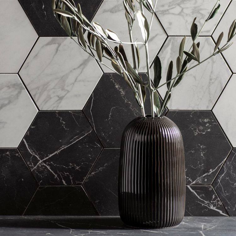 Marmi Nero Honed Hexagon Mosaic dark hexagonal marble mosaic with a black ribbed vase of olive branches