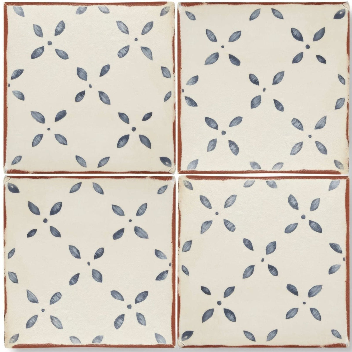 Cream-colored ceramic Marrakech El Hara patterned terracotta tile with blue floral pattern and rustic brown edges