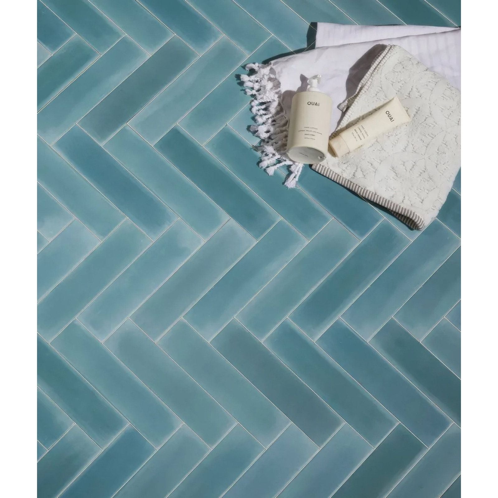 Medina brick porcelain aqua teal herringbone patterned glass tile floor with a glossy finish