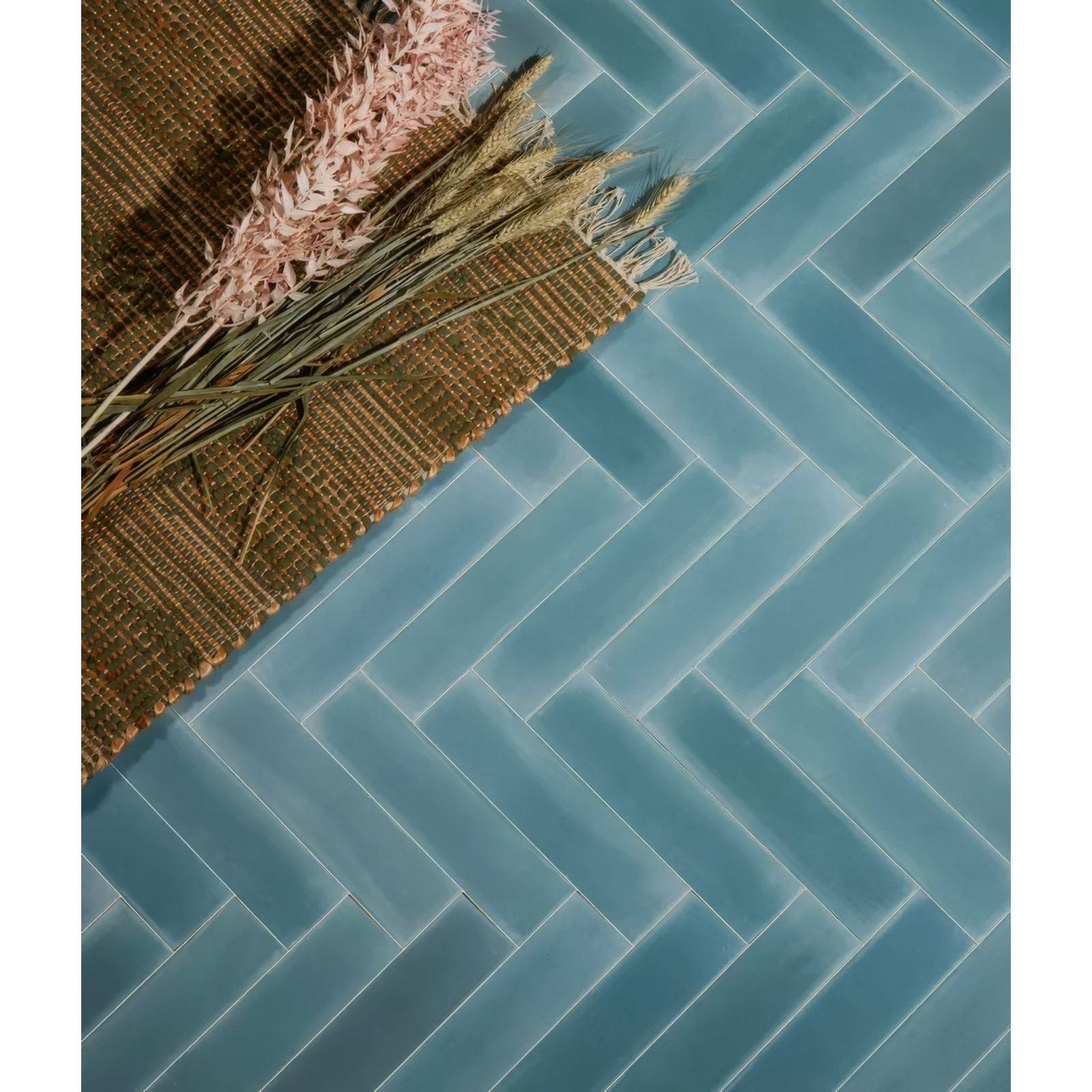 Blue glossy medina brick porcelain aqua subway tiles arranged in a herringbone pattern