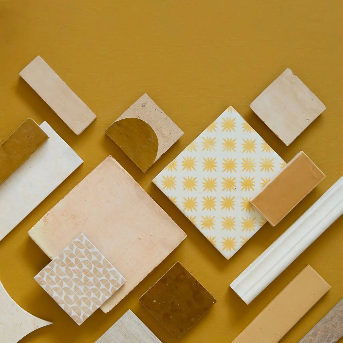 A square ceramic Medina ochre Belen handmade Moroccan zellige tile with a white background and yellow sunburst patterns