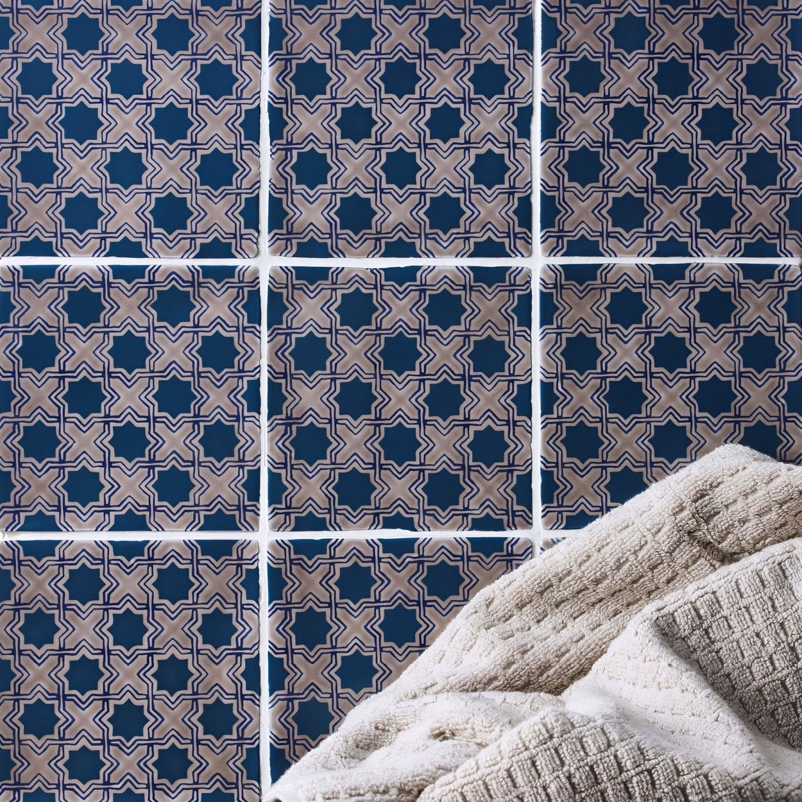 Beige textured towel from merles on truffle resting against navy blue and beige geometric patterned tiles