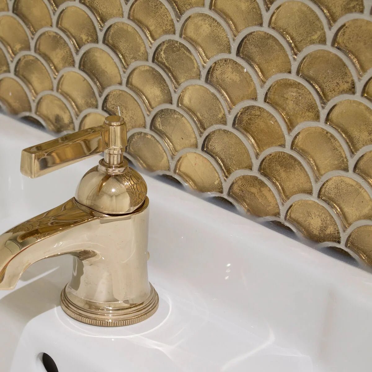 Gold-toned metallic vitreum aurum fan gold glass tile with polished reflective finish and elegant curved faucet spout