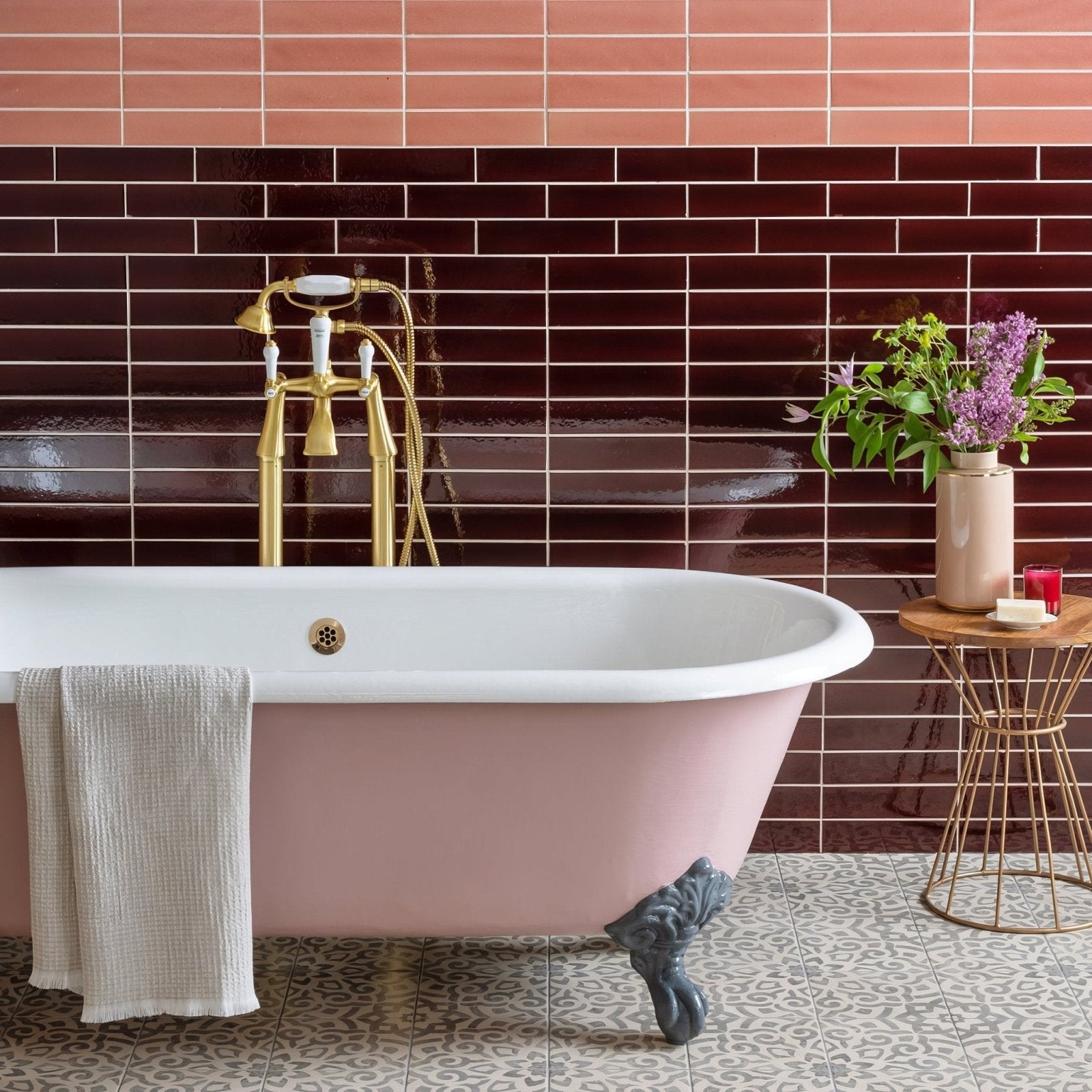 Mezzo Fantasia pink clawfoot bathtub with white porcelain interior and gold toned fixtures for elegant bathing