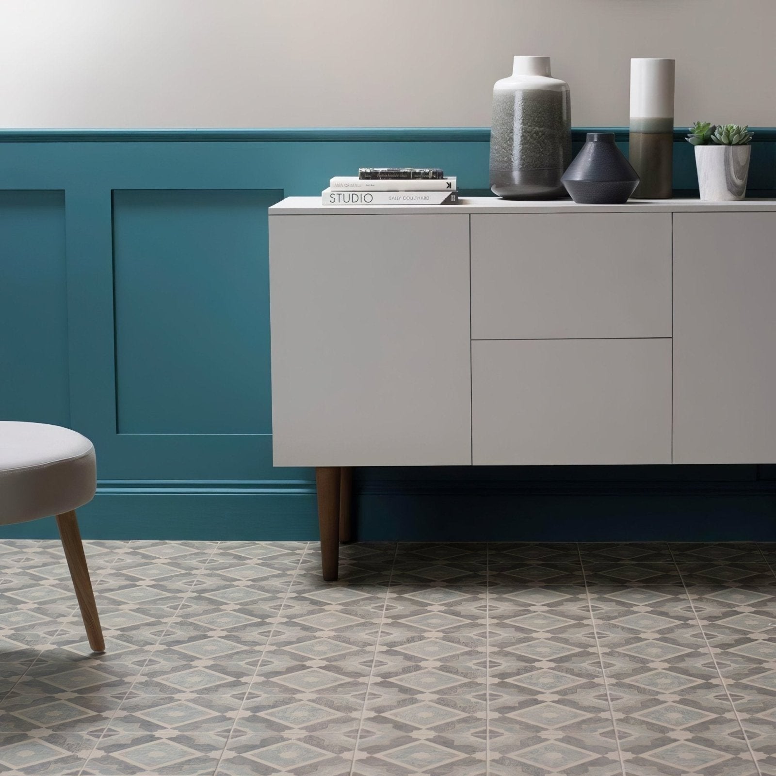 White modern sideboard mezzo volante with wooden legs against a teal paneled wall for stylish storage
