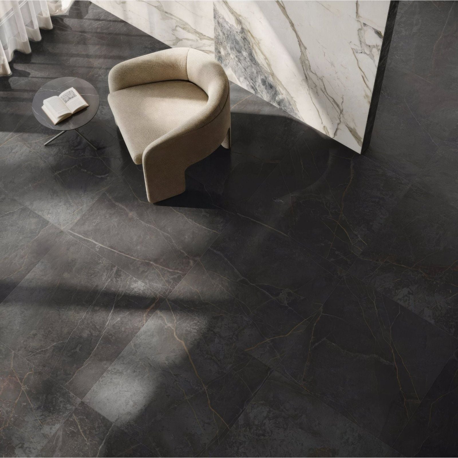 Milos Black 80 x 80cm dark grey marble-effect tiles with a beige armchair