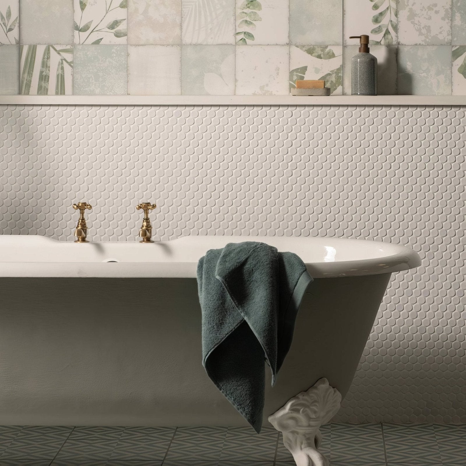 White clawfoot bathtub with gold faucets and teal towel featuring mini white penny round tile backdrop