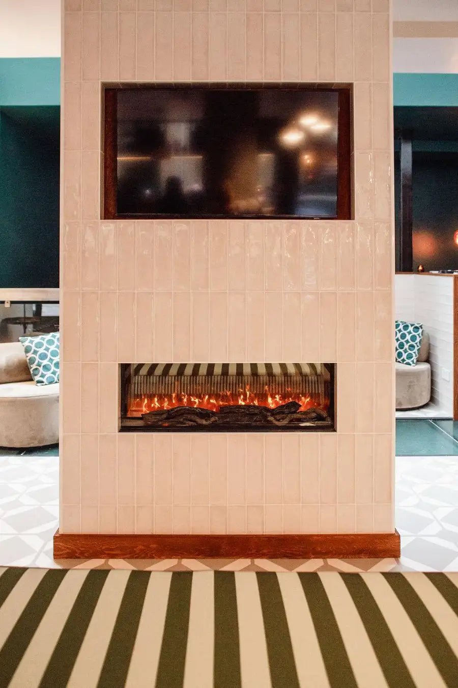 A modern electric fireplace with a sleek, rectangular design set into a tiled wall panel.
