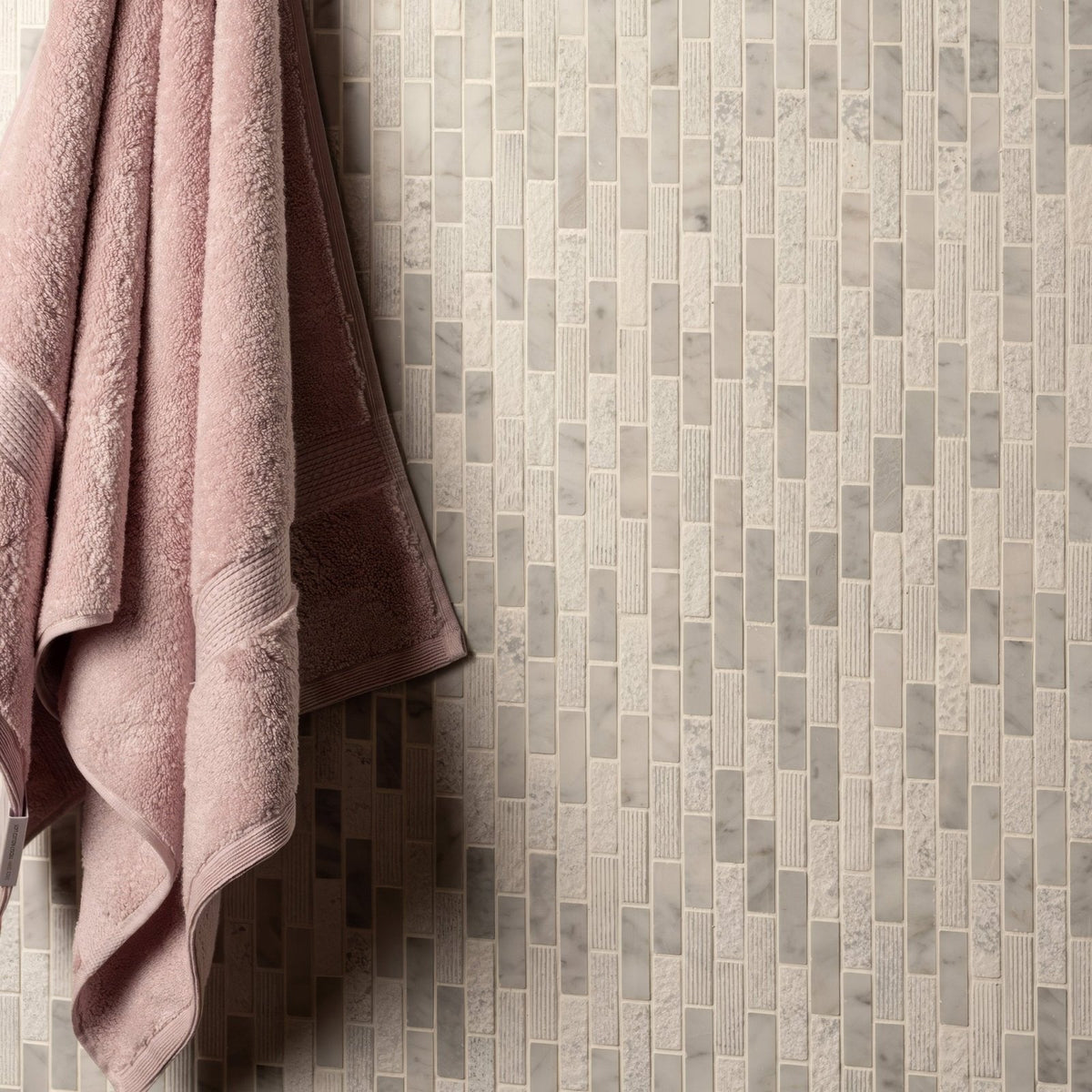 Nares Brickbond Marble Mosaic white marble brick mosaic with a soft pink towel