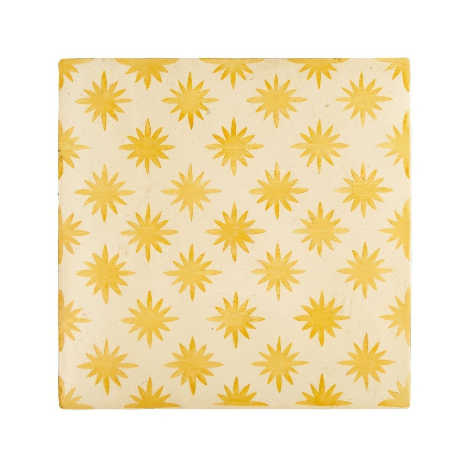 Cream-colored ceramic tile with golden-yellow starburst pattern from neisha crosland atlas star anise buttercup collection