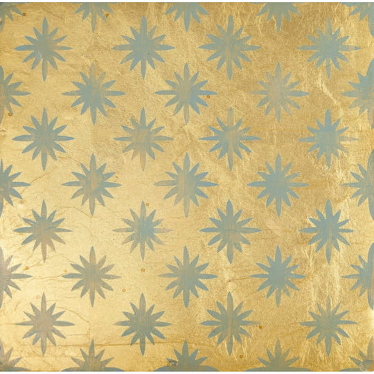 Golden foil wallpaper with a repeating pattern of light blue starburst motifs from neisha crosland atlas star anise sahara