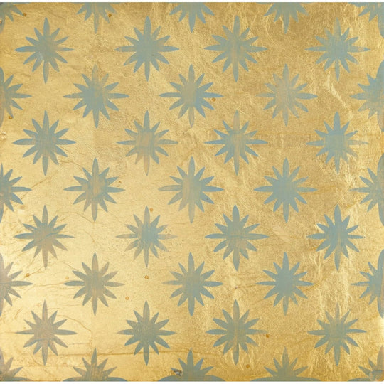 Golden foil wallpaper with a repeating pattern of light blue starburst motifs from neisha crosland atlas star anise sahara