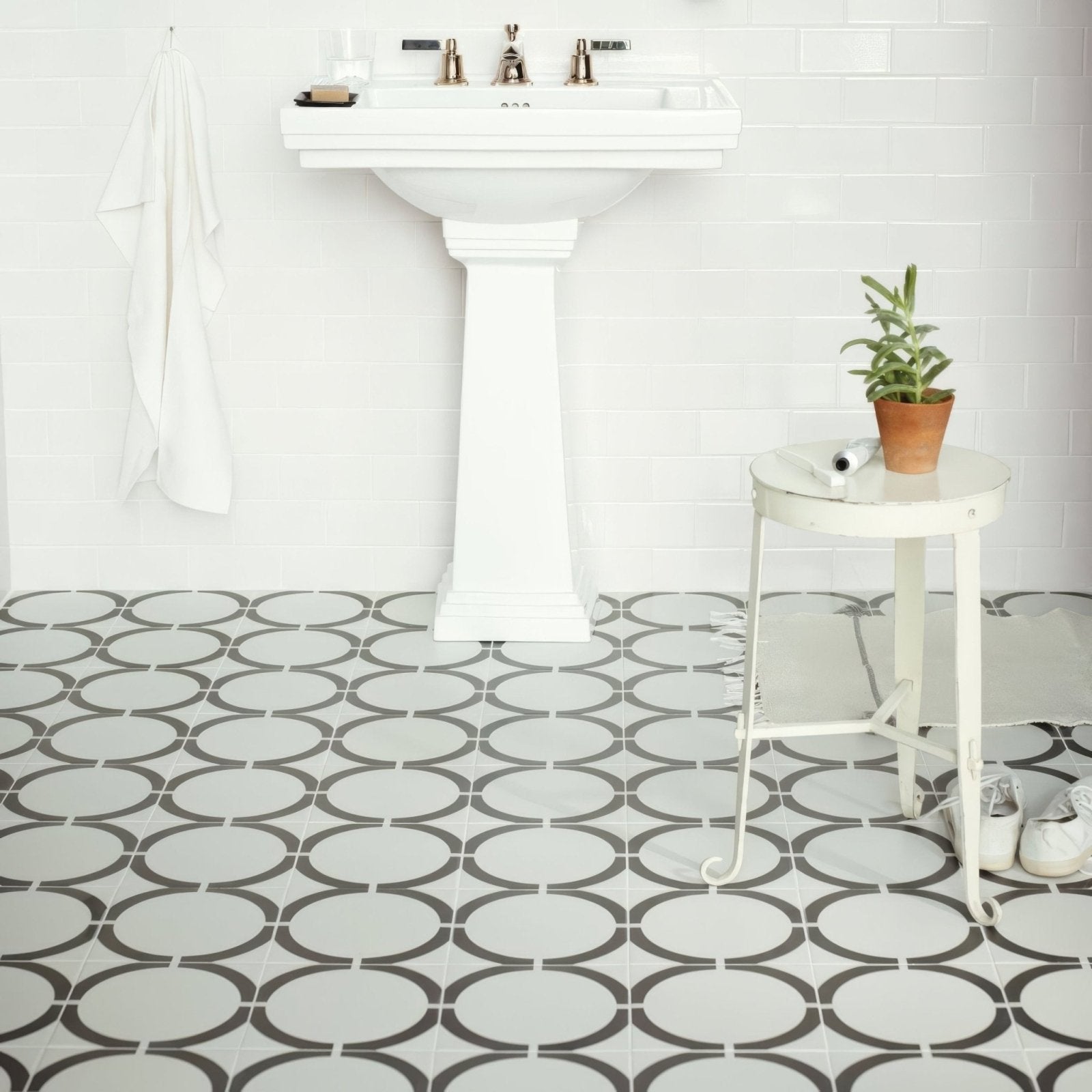 White pedestal sink with chrome faucets featured in neisha crosland tulia hula hoop black product design