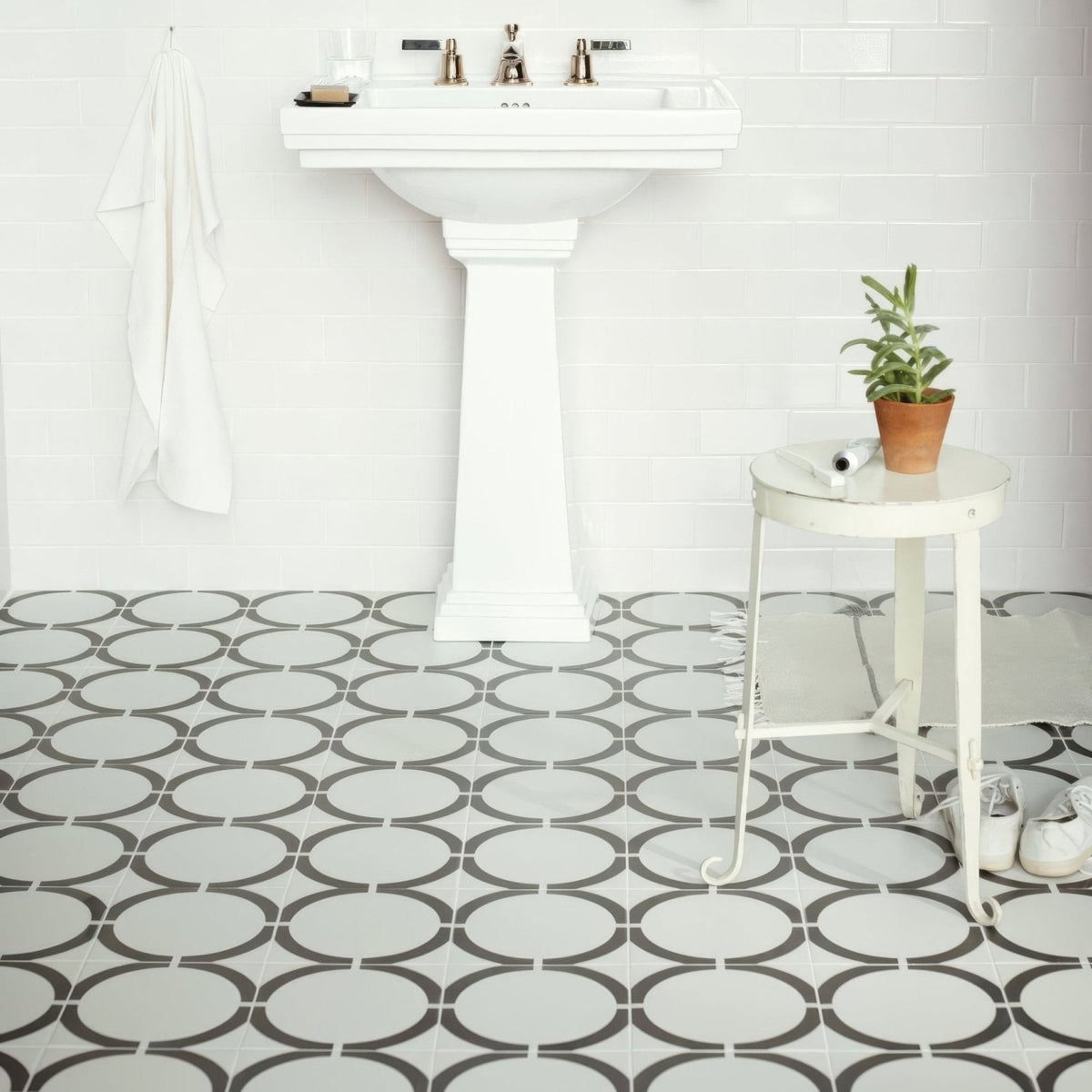 White pedestal sink with chrome faucets featured in neisha crosland tulia hula hoop black product design
